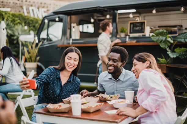 pessoas multirraciais se divertindo fazendo selfie em food truck ao ar livre - foco no rosto do homem africano - group of people people family multi ethnic group - fotografias e filmes do acervo