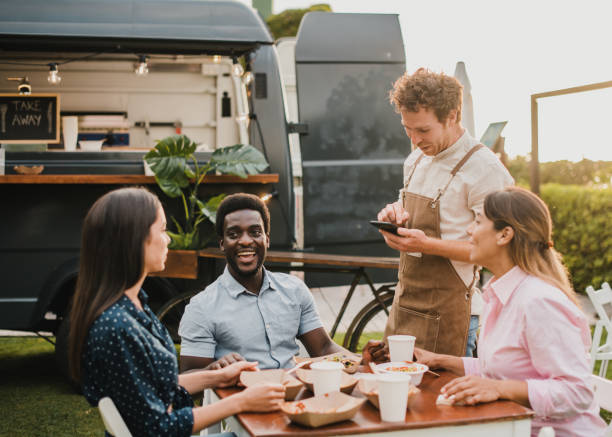 Multiracial people ordering food at food truck outdoor - Focus on african man face Multiracial people ordering food at food truck outdoor - Focus on african man face friends in bar with phones stock pictures, royalty-free photos & images