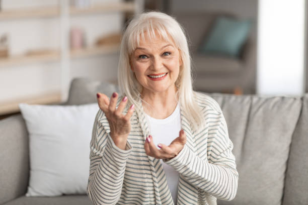 istock Mature woman talking at camera gesturing and smiling 1331254830