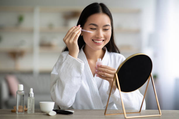 istock Beautiful asian lady applying eye serum and smiling 1331255537