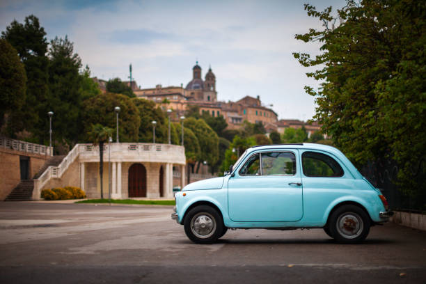 Old Italian Car from 60's with Macerata Marche cityscape in the back Old Italian Car on parking with Macerata Marche cityscape in the background macerata italy stock pictures, royalty-free photos & images