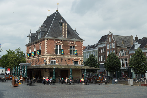 Leeuwarden, The Netherlands, july 7, 2021.The weigh house in the center of Leeuwarden, Nowadays a cafe and restaurant with people on the outside terrace, enjoying a cup of coffee or a drink.