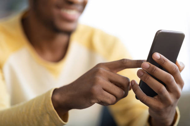 Closeup of modern smartphone in african american guy hands