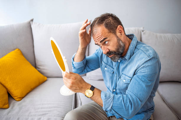 istock Middle-aged man concerned by hair loss. 1331257399