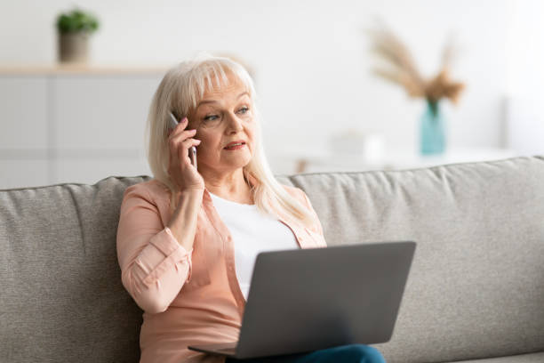 istock Mature woman working and talking on cellphone at home 1331257546