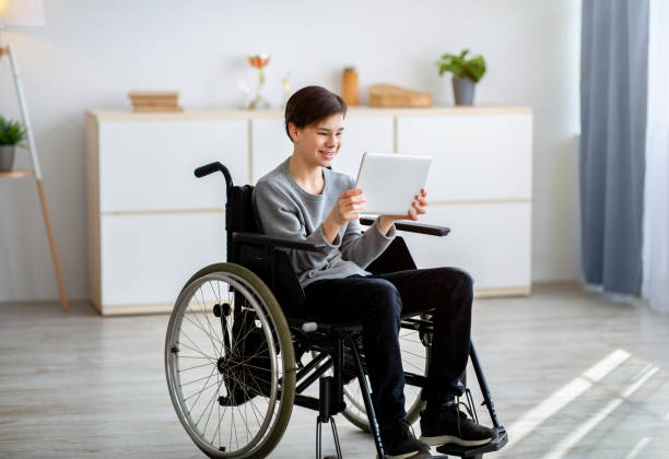 istock Web-based education. Joyful teenage student in wheelchair with tablet pc having online lesson at home 1331257782