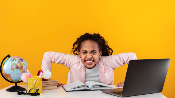 istock Furious african school girl looking at camera using laptop 1331259195