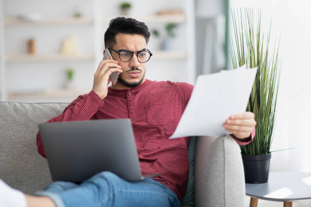 istock Middle-eastern businessman working from home, having phone conversation 1331259636