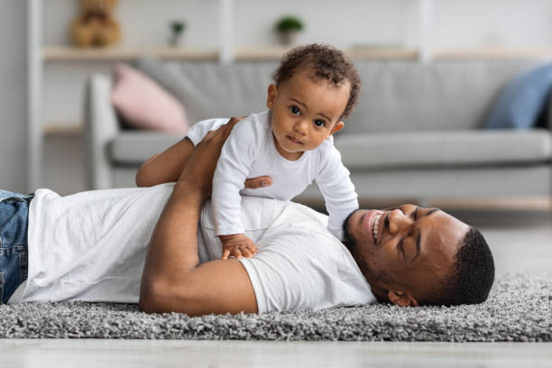 istock Adorable Baby Boy Lying On Father's Chest While They Relaxing At Home 1331260921