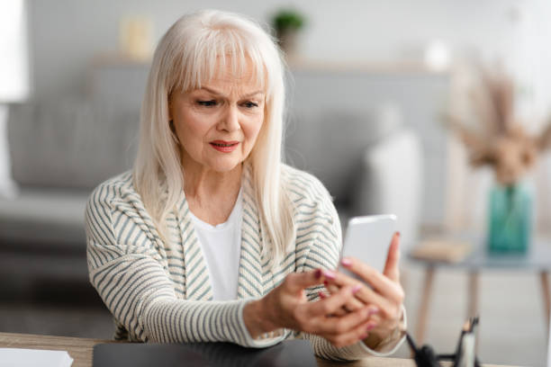 istock Shocked senior woman using her mobile phone 1331261170