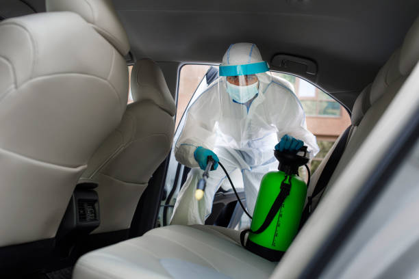 istock Employer in protective suit with mask disinfecting inside car 1331263983