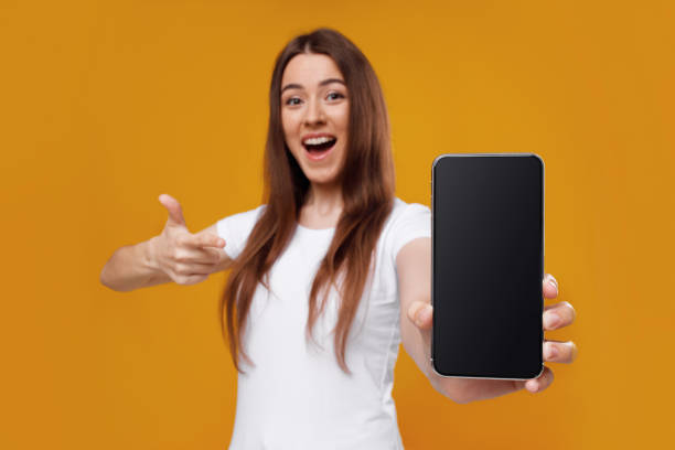 istock Excited young lady showing brand new smartphone with empty screen 1331266627