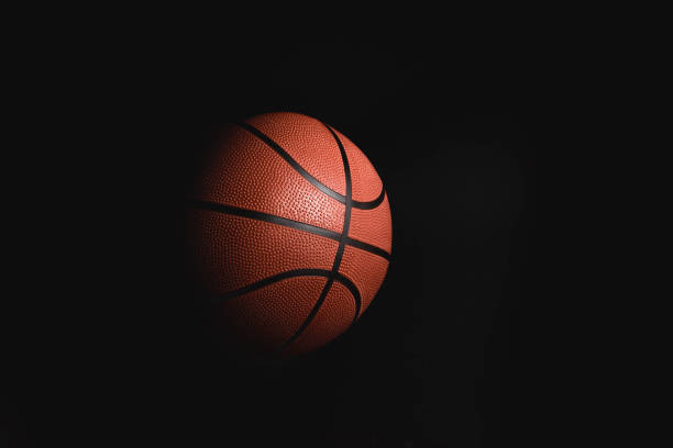 Basketball on black background in the dark with copy space