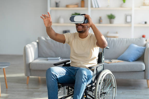 istock Disabled young black man in wheelchair exploring augmented reality in VR goggles at home 1331267807