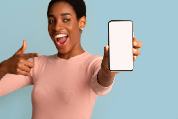 istock Great App. Excited Black Female Pointing At Smartphone With Blank White Screen 1331268150
