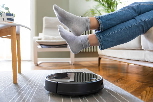 Robot vacuum cleaner cleaning the living room stock photo