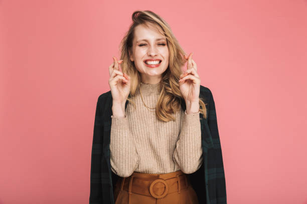 portrait of pretty blond woman 30s in stylish outfit keeping fingers crossed and wishing for fortune or luck - silence finger on lips businesswoman one person imagens e fotografias de stock