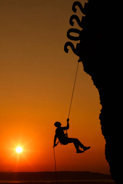 istock Man climbing on rock with 2022 New Years Concept 1331273450