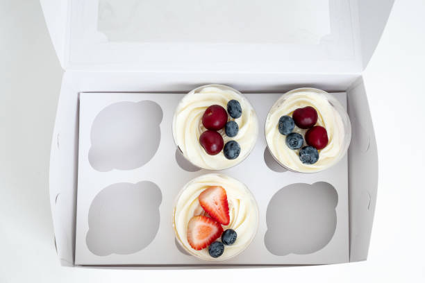 istock Top view on half-empty set box of cakes with cream and fresh berries 1331273496
