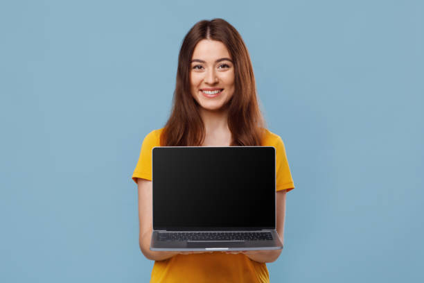 istock Pretty young lady showing laptop with empty screen 1331273768