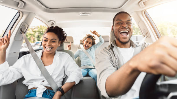 Happy Black Family Of Three Singing Having Fun Riding Car Summer Road Trip. Happy Black Family Of Three Riding Car And Singing Having Fun Traveling By Automobile. Parents And Daughter Enjoying Auto Ride Together On Weekend. Panorama, Selective Focus travel destinations family stock pictures, royalty-free photos & images