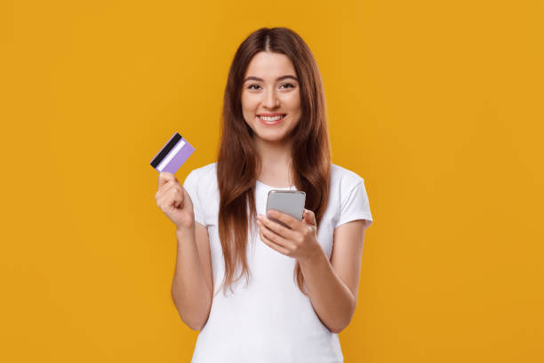 istock Happy young lady with smartphone and credit card 1331273805