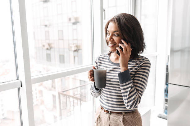 istock Smiling african woman using mobile phone 1331274038