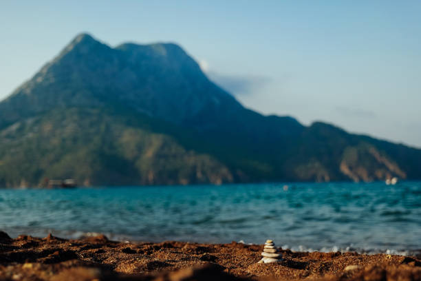 Beautiful Adrasan, Turkey. Mediterranean sea and mountain view on sunset. Small stone pyramid in front view