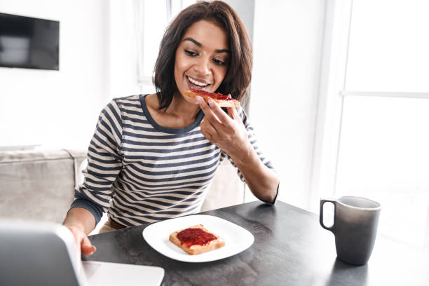 istock Smiling young african woman having breakfast 1331275206