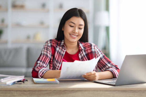 istock Young Asian Freelancer Woman Working With Documents And Laptop At Home Office 1331275219