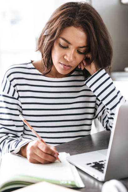 istock Attractive young african woman using laptop computer 1331275741
