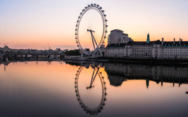 London Eye ferris wheel reflecting in Thames Southbank sunrise panorama stock photo