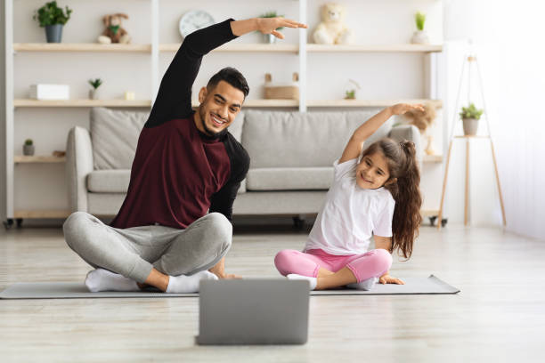 istock Smiling father and daughter having online yoga class 1331278355