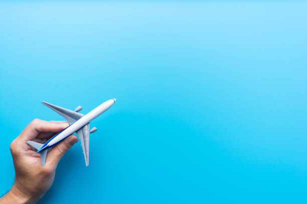 Top view of model airplane isolated on blue Top view of man hand hold model airplane with isolated on blue background for design mock up toy airplane stock pictures, royalty-free photos & images