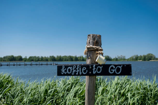wooden sign with dutch words koffie to go "coffee to go" on the background of wooden board in a outside environment - koffie imagens e fotografias de stock