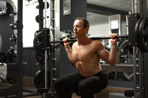 istock Senior man working out at the gym doing squats 1331280639