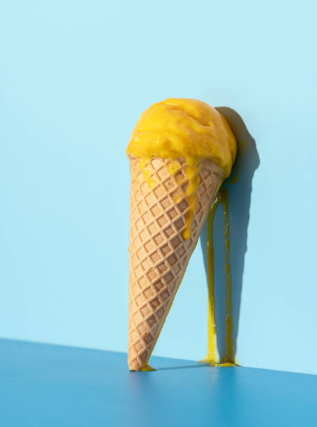 istock Melting ice cream on a blue background. Mango ice cream in a cone. 1331283589