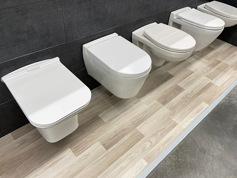 Group of different white toilets in the showroom