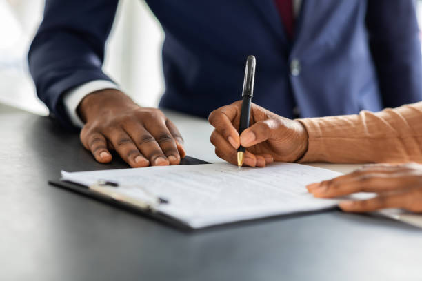 Contract Signing. Female Customer Sign Papers In Dealership Office, Closeup Shot Contract Signing. Female Customer Sign Papers In Dealership Office, Unrecognizable African American Woman Client Buying New Car Or Purchasing Property, Closeup Shot, Cropped Image With Free Space paperwork stock pictures, royalty-free photos & images