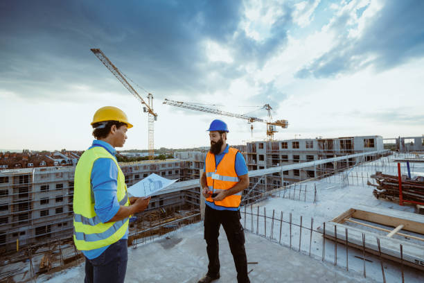 istock Engineers and contractors looking at blueprint on construction site 1331285628