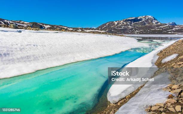Frozen Turquoise Lake Vavatn Panorama In Summer Landscape And Mountains With Snow In Hemsedal Norway Stock Photo - Download Image Now