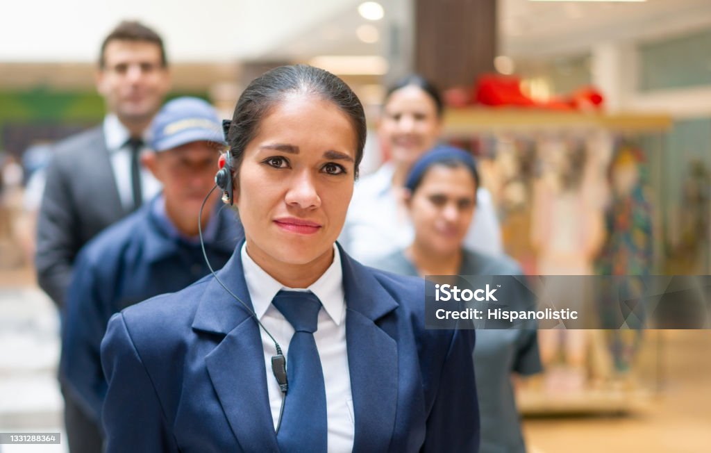 Security guard with a group of workers at a shopping mall Portrait of a Latin American Security guard with a group of workers at a shopping mall - staff concepts Security Guard Stock Photo
