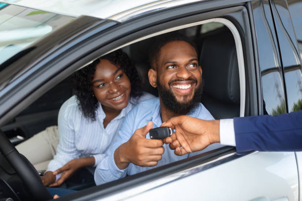 新しい車を購入した後、セールスマンから鍵を取る幸せなアフリカ系アメリカ人のカップル - car african descent shopping car dealership ストックフォトと画像