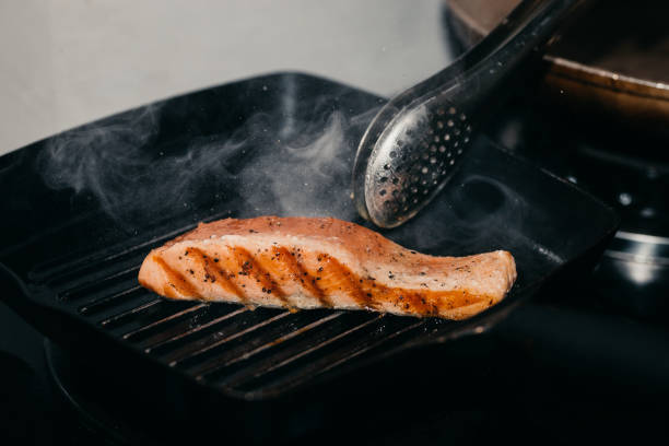 istock Chef Hand Pan Seared Salmon Fillet At home 1331288650