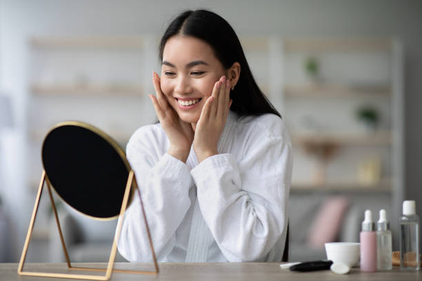 istock Pretty asian woman in bathrobe making face-lifting massage 1331289636