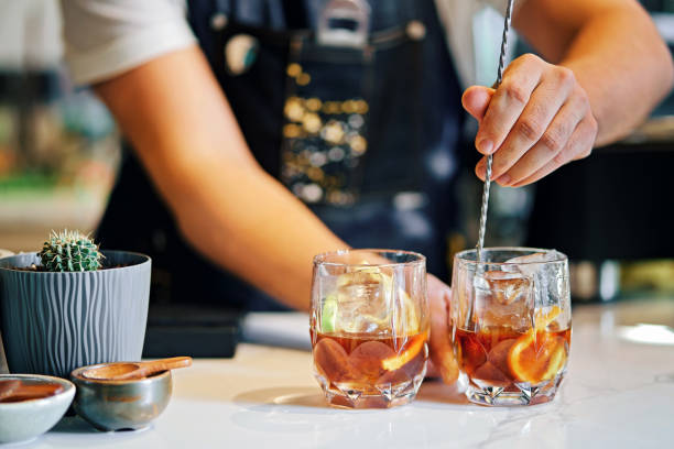 bartender mixing cocktails in bar - kokteyl stok fotoğraflar ve resimler