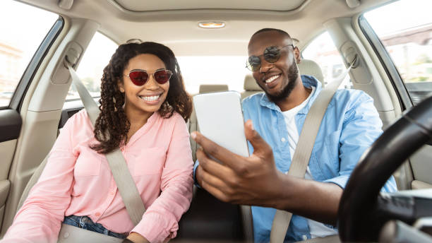 istock Happy black couple driving car and using smartphone 1331291840