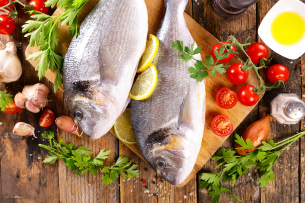 istock raw fish won wooden board with ingredients and spices 1331292107
