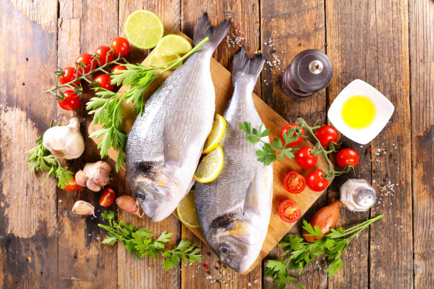 istock raw fish won wooden board with ingredients and spices 1331292108