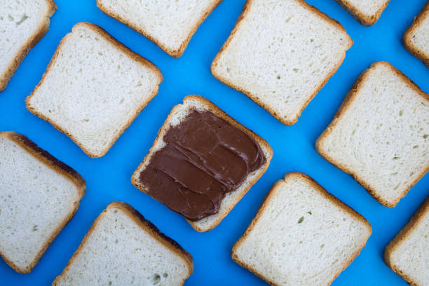 istock Toast bread  and one slice with chocolate cream on the blue background.Top view. 1331292275